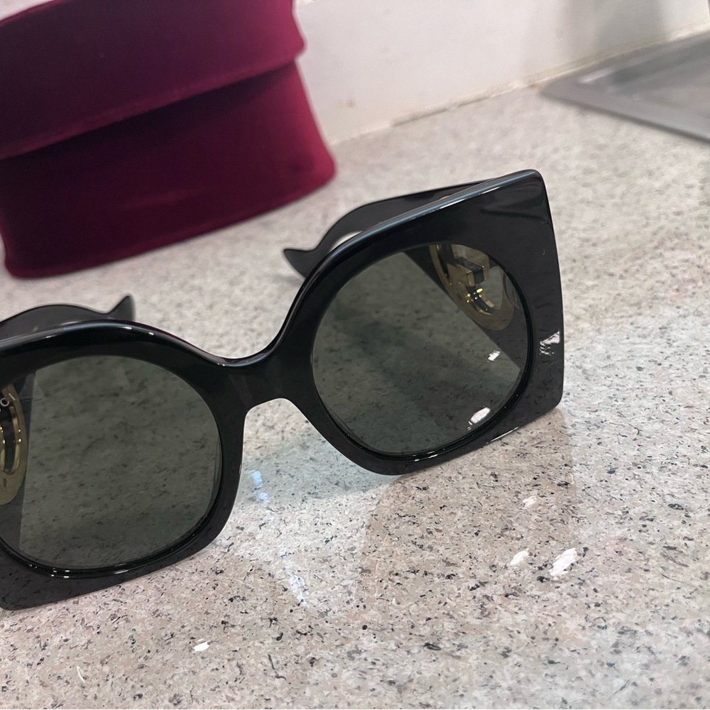 Oversize black Gucci, sunglasses with the gold side